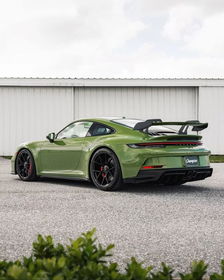 a green sports car parked in front of a building