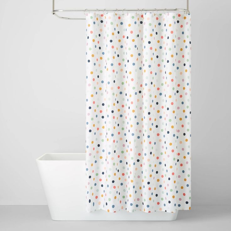 a white shower curtain with multicolored polka dots