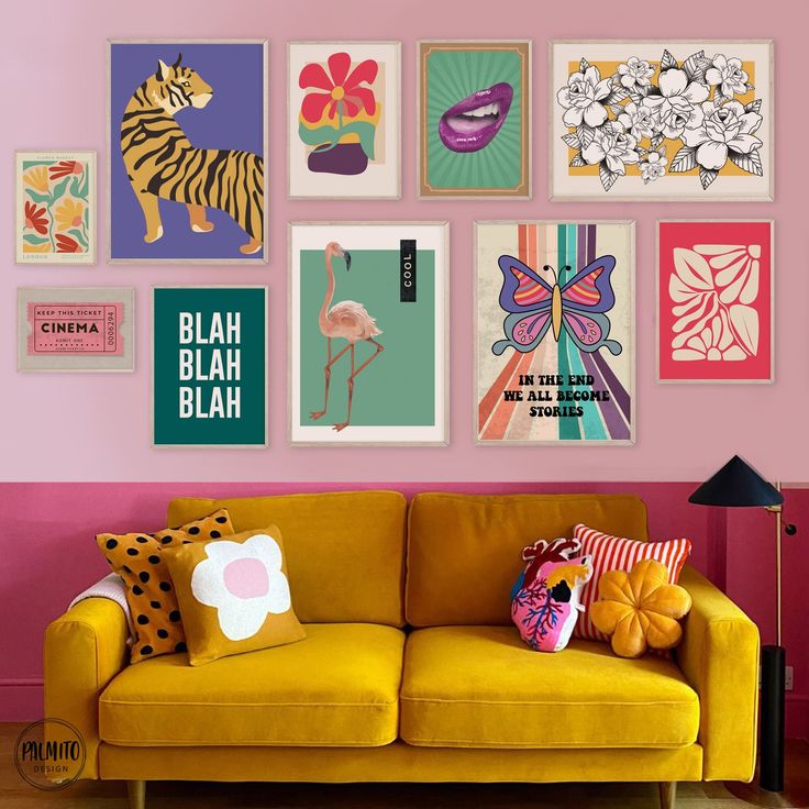 a yellow couch sitting in front of a pink wall with pictures on the wall above it