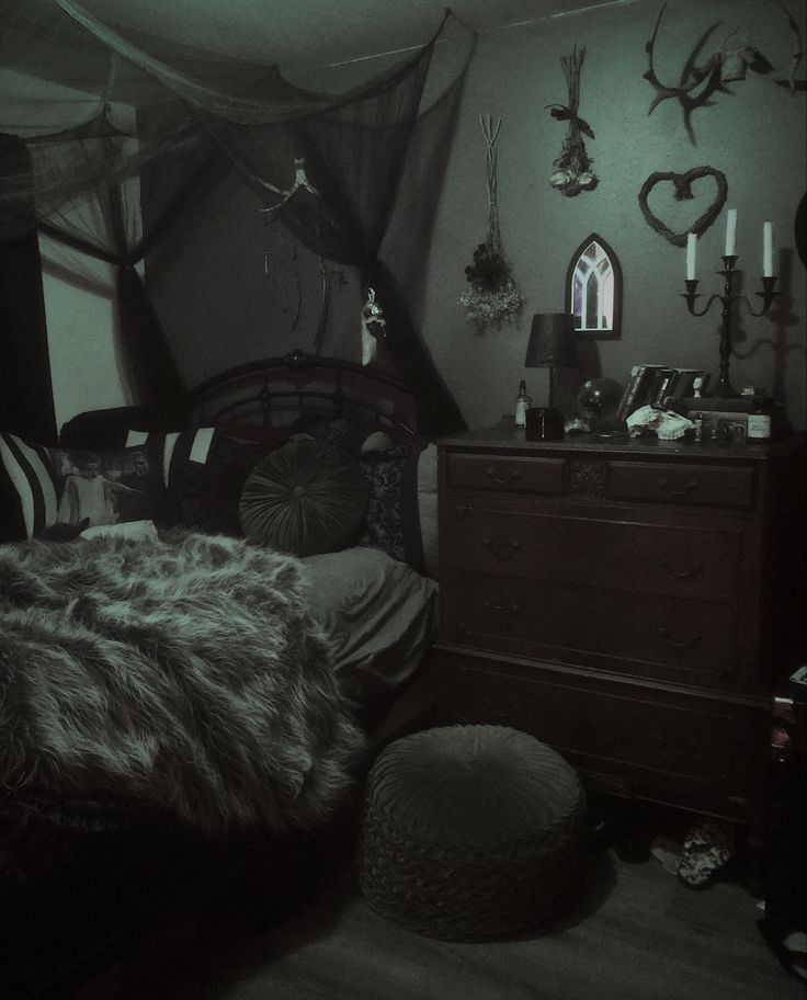 a bedroom with a bed, dresser and mirror in the corner is lit up by candles