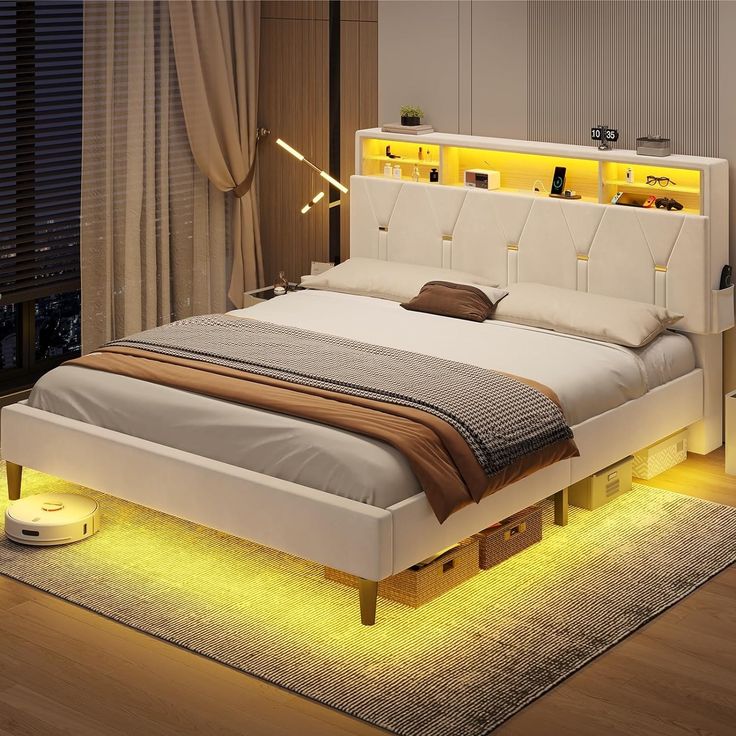 a bed that has some lights on the headboard and night stands in front of it