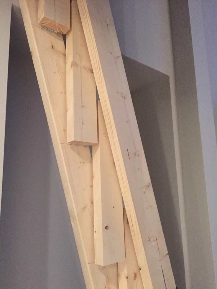 an unfinished stair case is being built in a room with gray walls and wood flooring