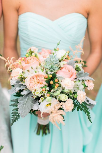 the bridesmaids are holding their bouquets in pastel blue and peach colors