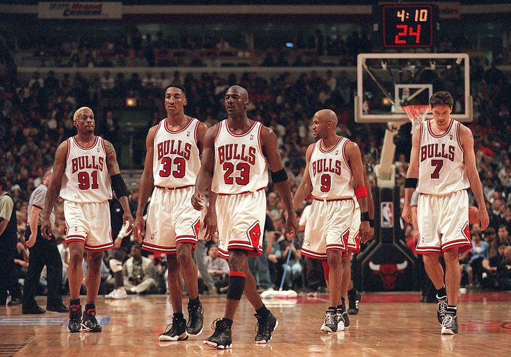 the chicago bulls are walking on the court in front of an arena full of fans