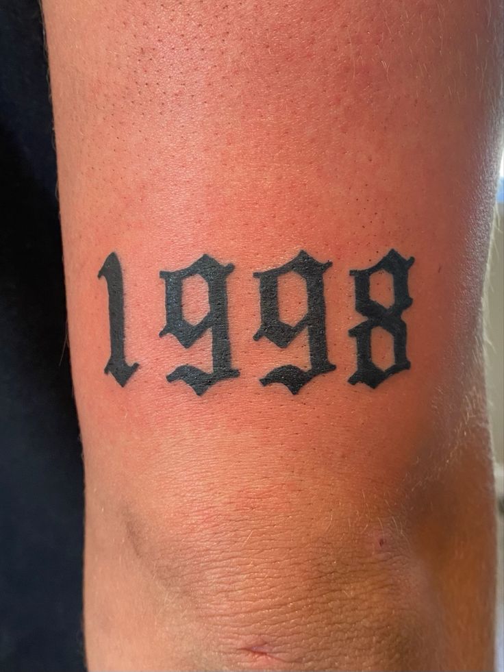 a person with a tattoo on their arm that says 999r in black ink