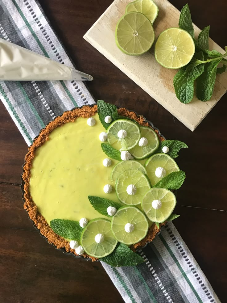 a pie with lime slices and mints on the top is ready to be eaten