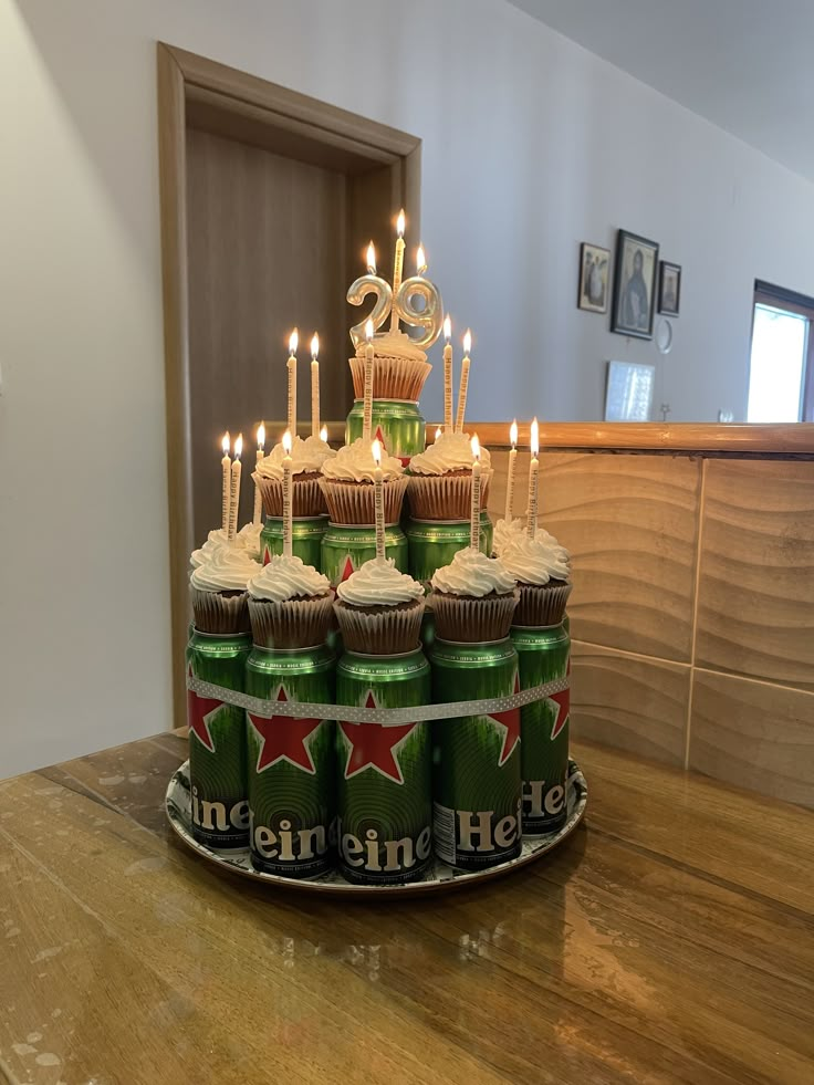 a birthday cake made to look like cupcakes with lit candles on top, sitting on a table