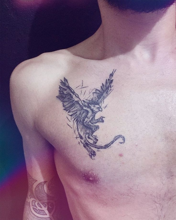 a man with a bird tattoo on his chest