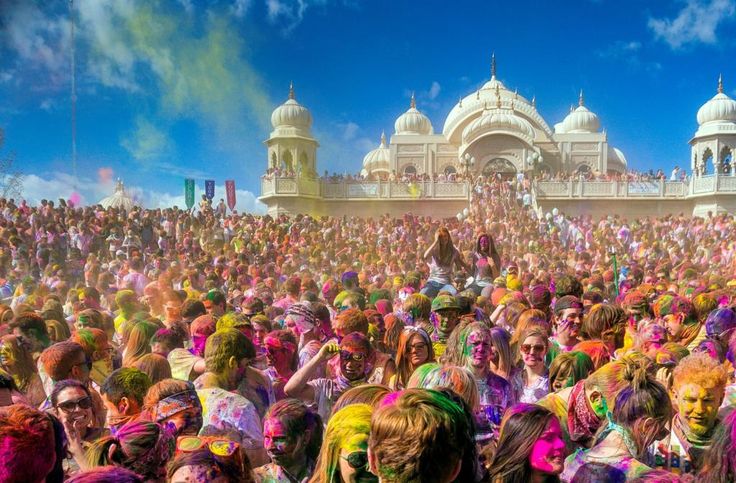 a large group of people covered in colored powder