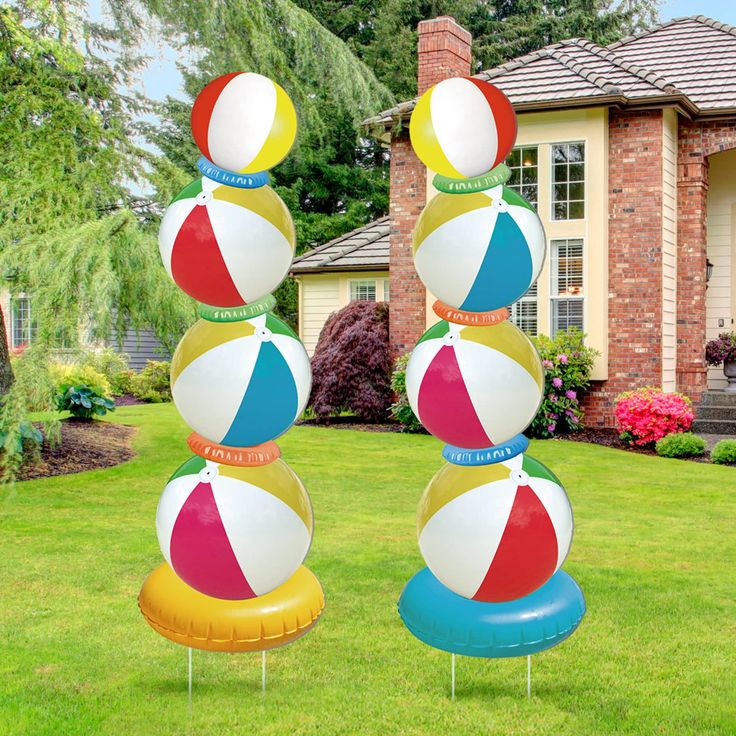 three inflatable beach balls are stacked on top of each other outside the house