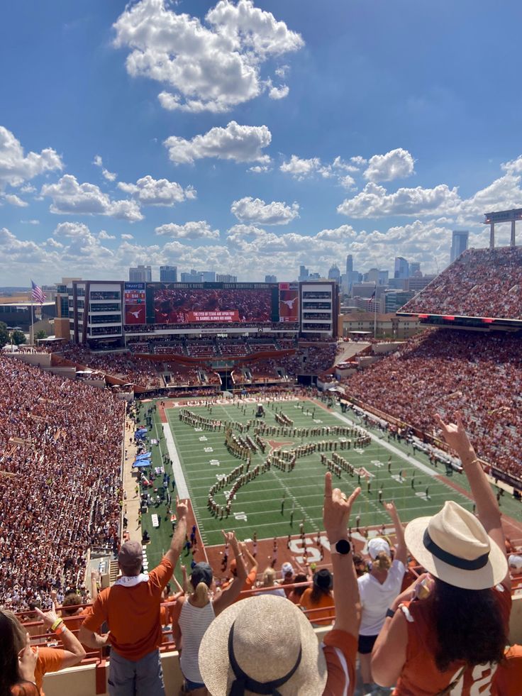 a football stadium filled with fans and cheerleaders watching the game from the stands