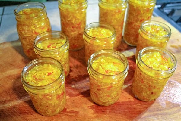 several jars filled with yellow food sitting on top of a wooden table