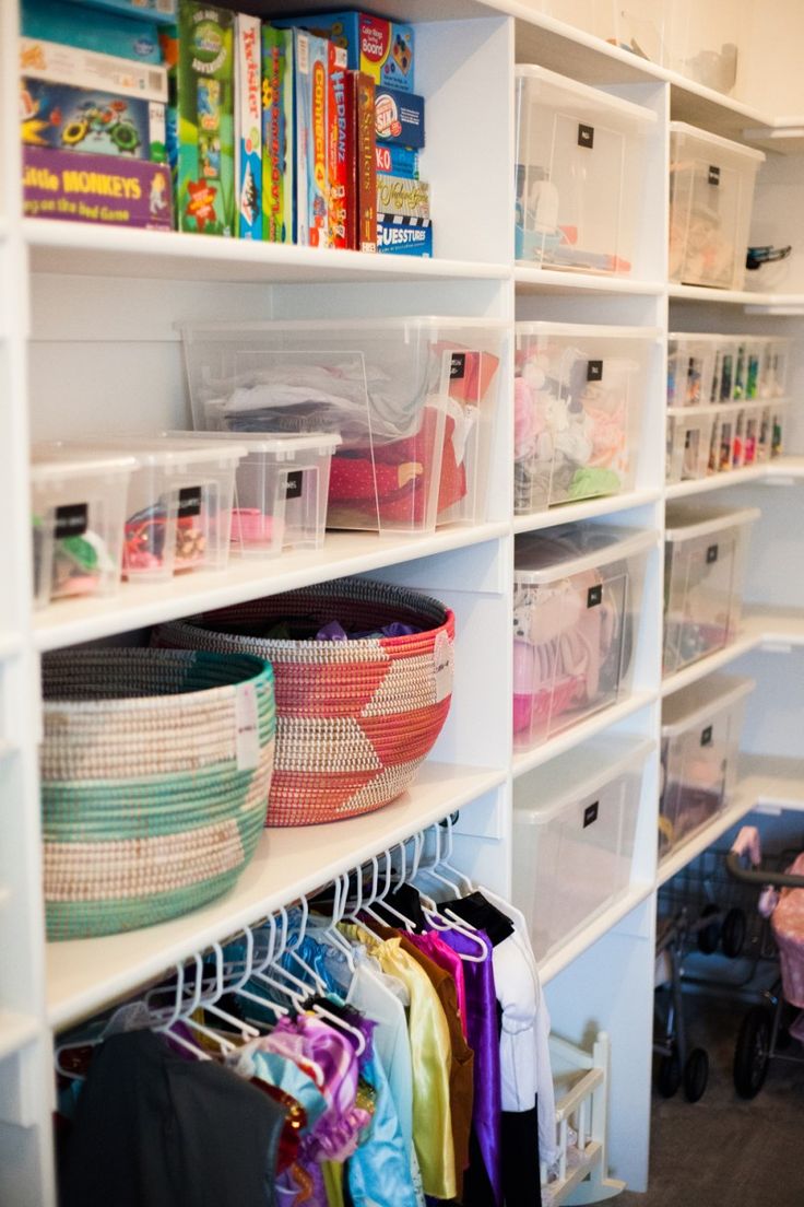 an organized closet with plastic baskets and other items