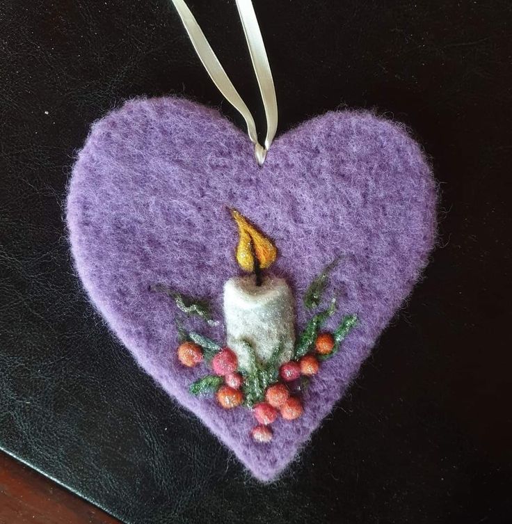 a heart shaped ornament with a candle on it