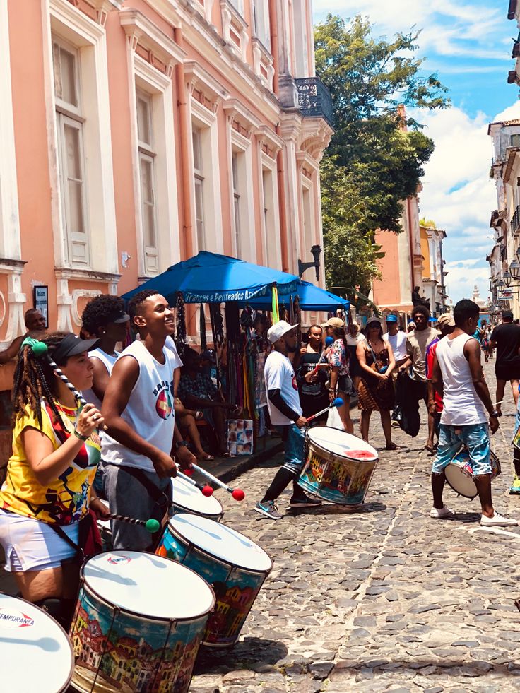 a group of people playing drums in the street