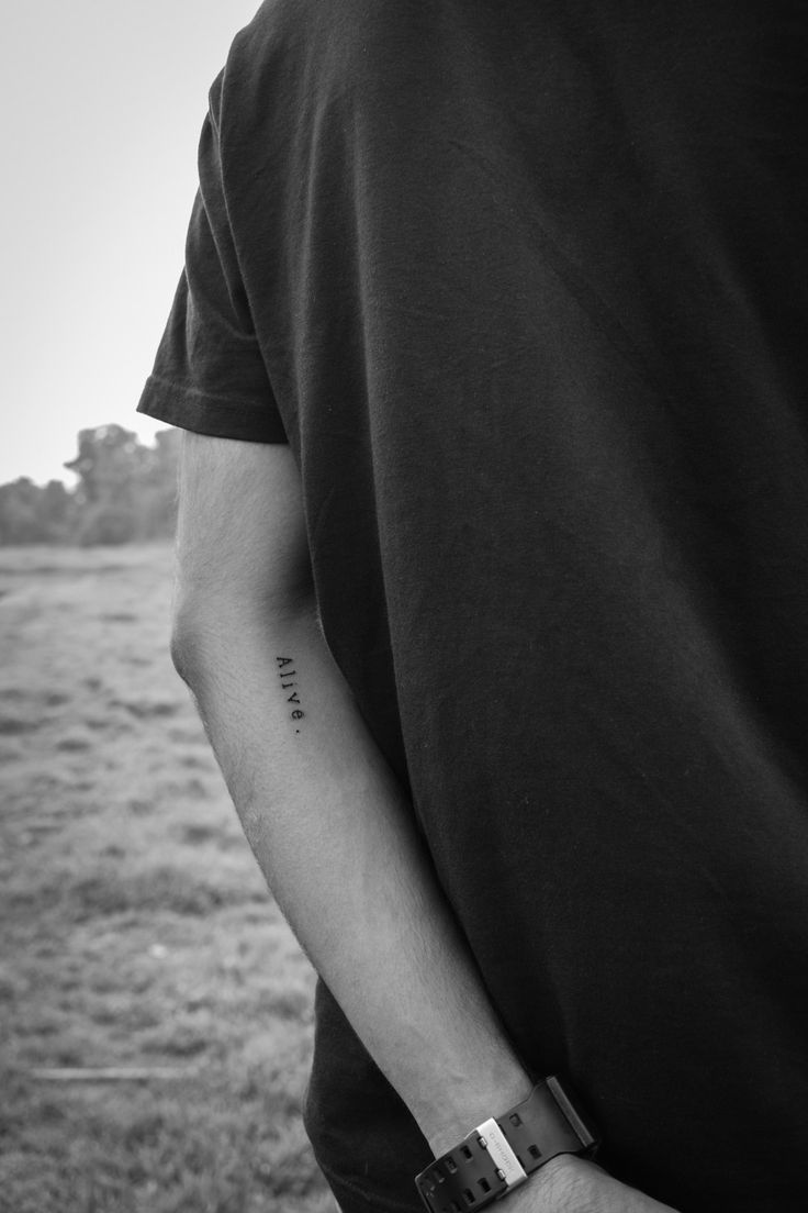 a man with a watch on his left wrist and the word love is written on his right arm