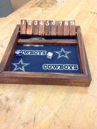 a wooden tray with numbers and dices in it