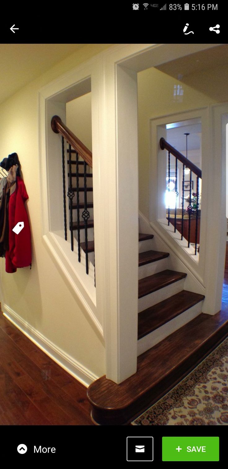 an entry way with stairs and wood floors in a home, which is painted white