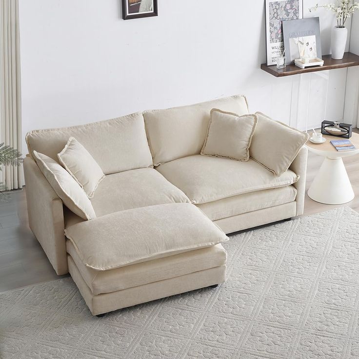 a living room with a large sectional couch and white rugs in front of it