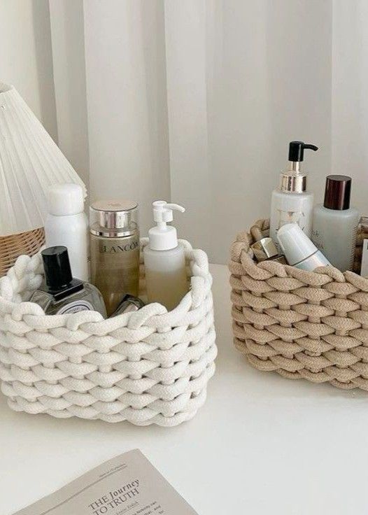 a white table topped with two baskets filled with personal care items next to a book