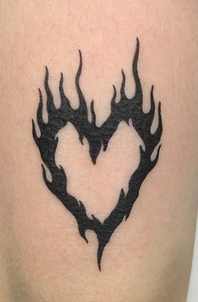 a black heart tattoo with flames on it