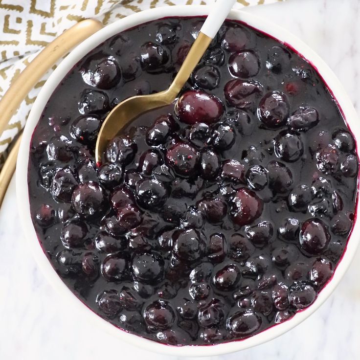 a bowl of blueberries with a spoon in it