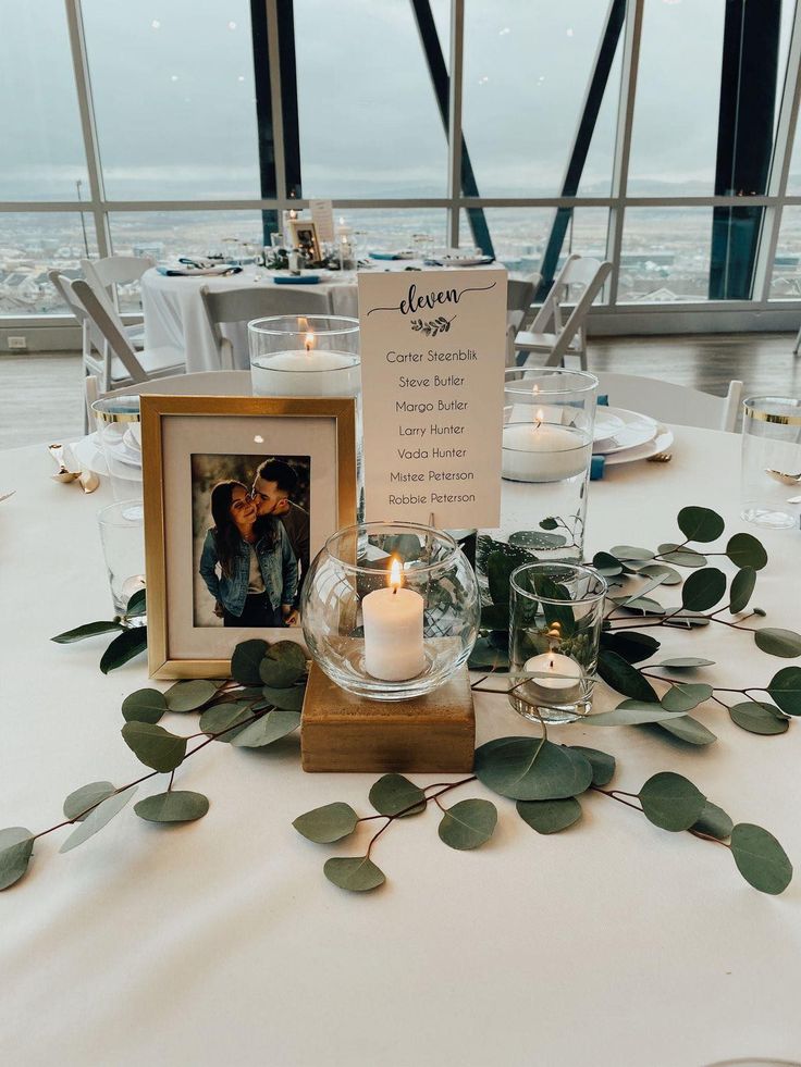 the table is set up with candles and greenery for an elegant wedding reception at the top of the building