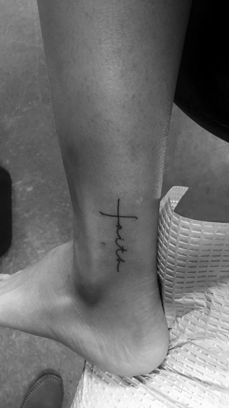 a person with a cross tattoo on their foot