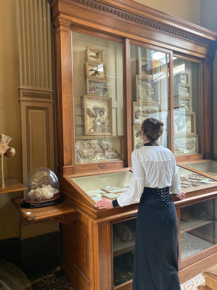 a woman standing in front of a display case