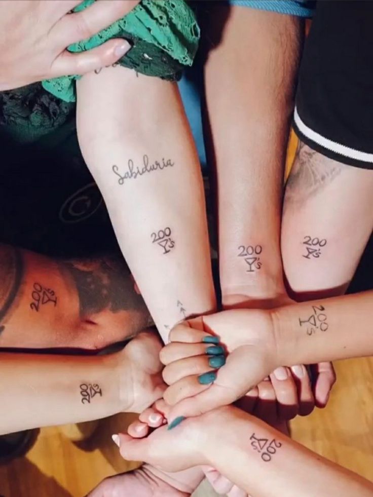 a group of people holding hands together with tattoos on their arms and wrist, all in the same row