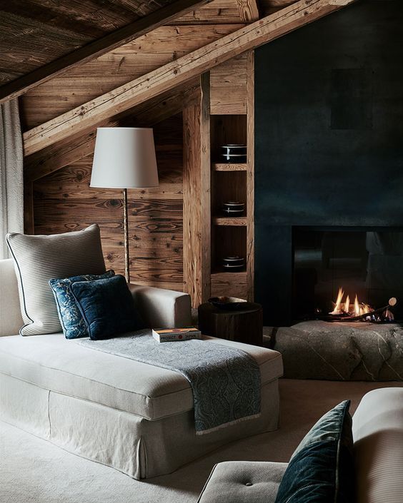 a living room filled with furniture and a fire place next to a wall mounted fireplace