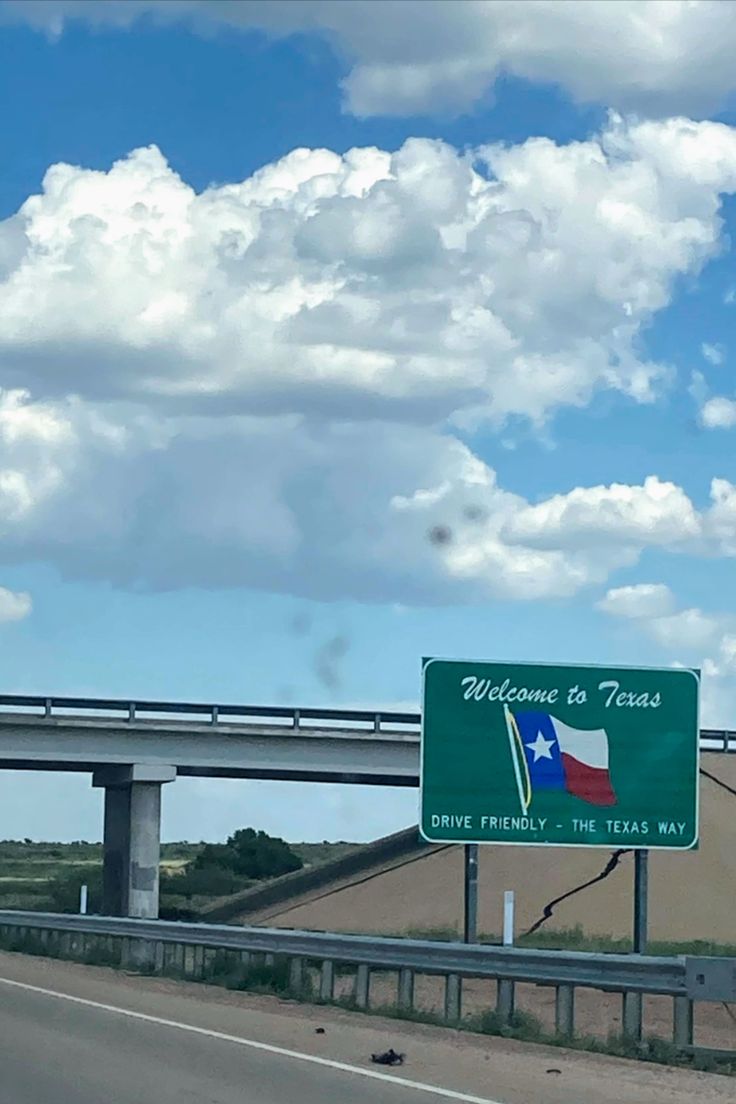 a highway sign with the word welcome to texas on it's side and an overpass in the background