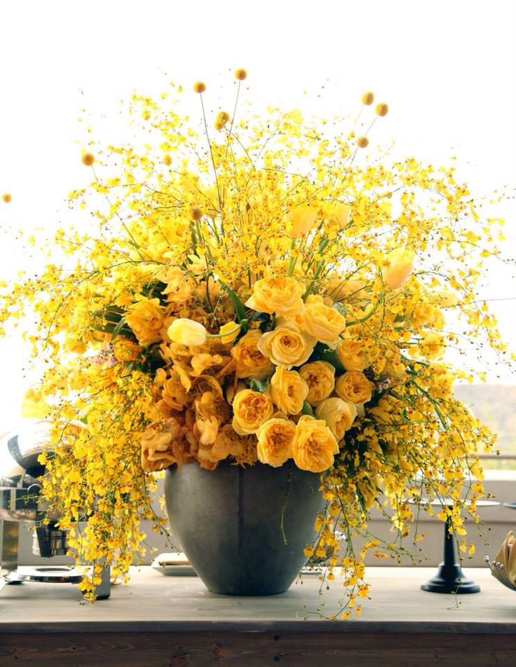 a vase filled with yellow flowers on top of a table