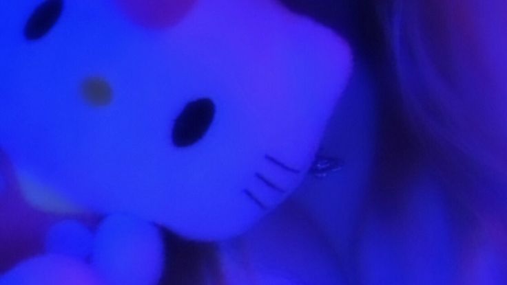 a close up of a person holding a hello kitty stuffed animal in front of her face