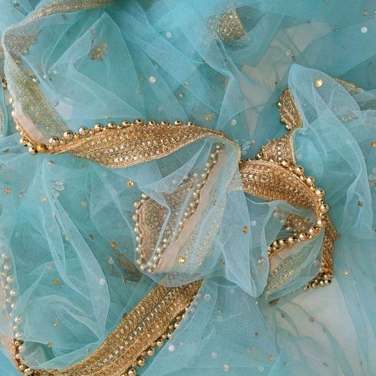 a blue and gold dress with lots of beads on it