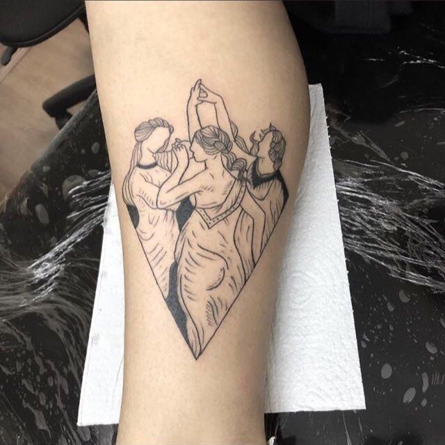 a woman's leg with a tattoo on it that has two people in the shape of a heart