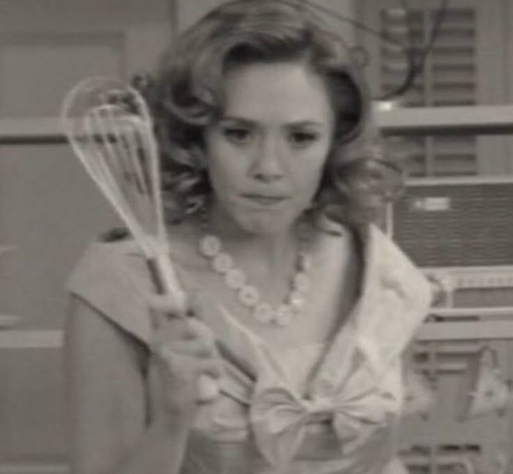 the woman is holding two whisks in her hands