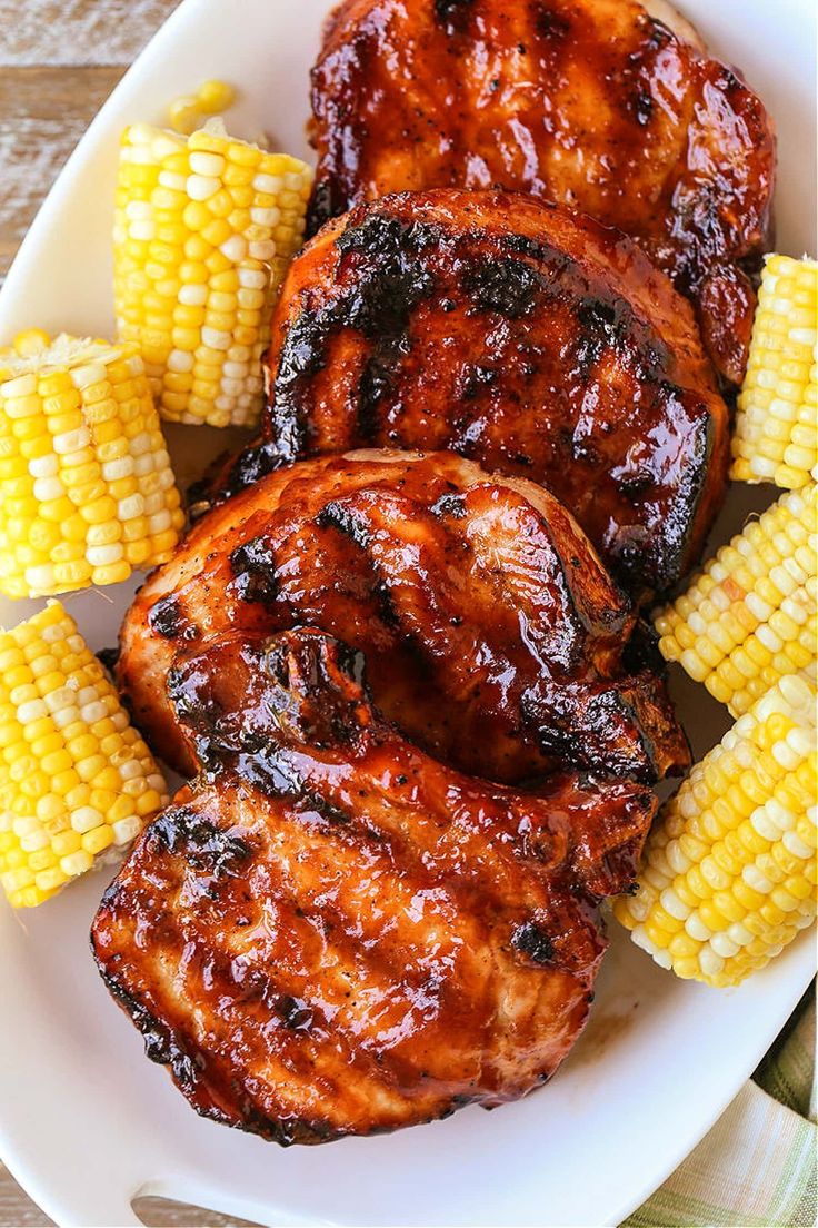 grilled chicken, corn on the cob and barbecue sauce in a white bowl