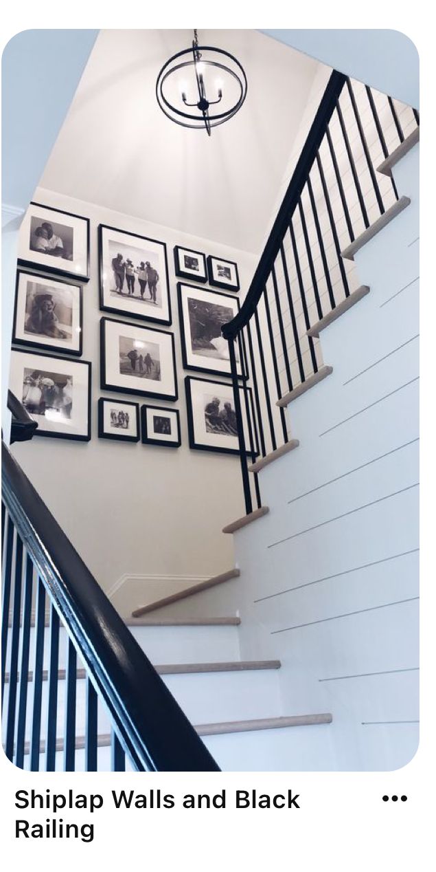 stairs and black railings with pictures on the wall