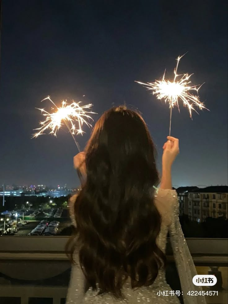 a woman is looking at fireworks in the sky