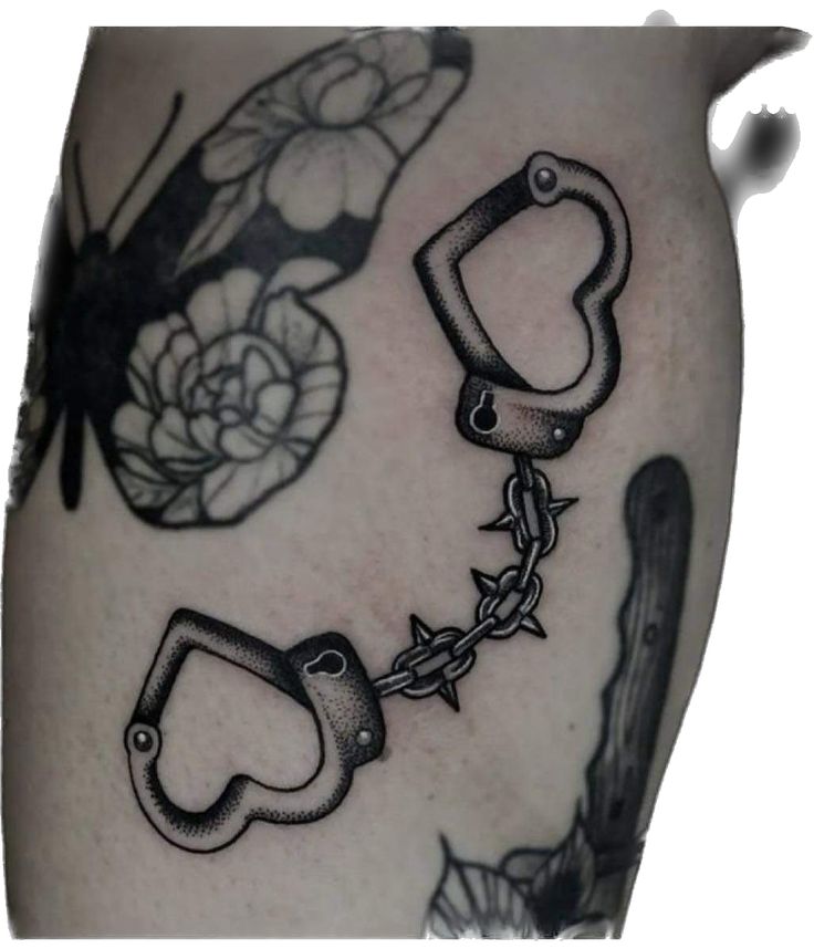 a black and white photo of some tattoos on someone's leg with chains attached to them