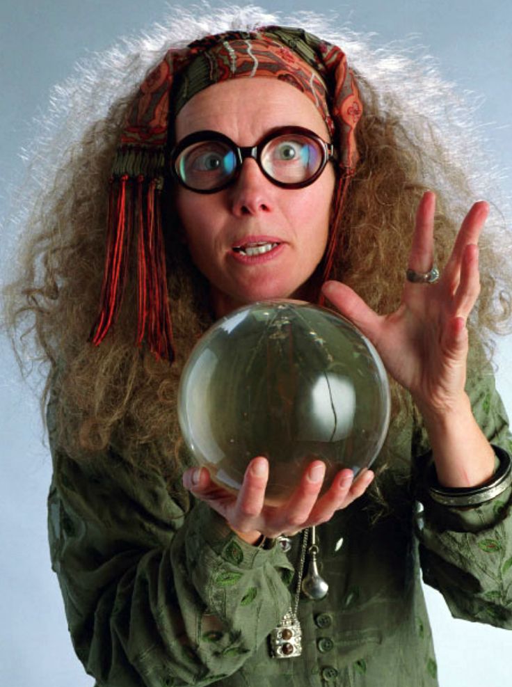 a woman wearing glasses holding a crystal ball in front of her face and making the peace sign