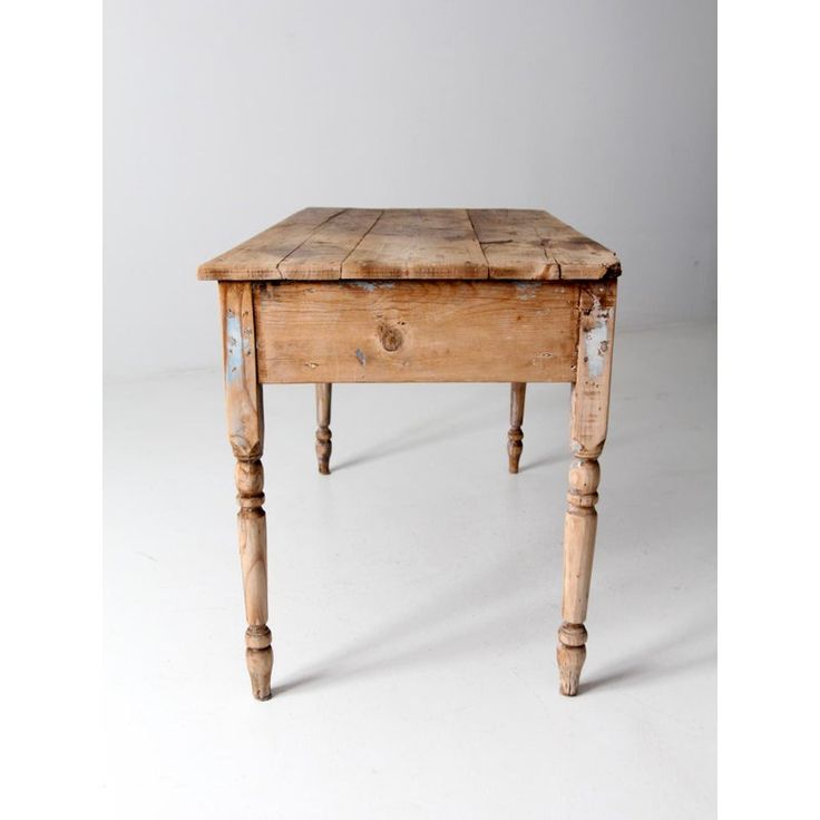 an old wooden table sitting on top of a white floor