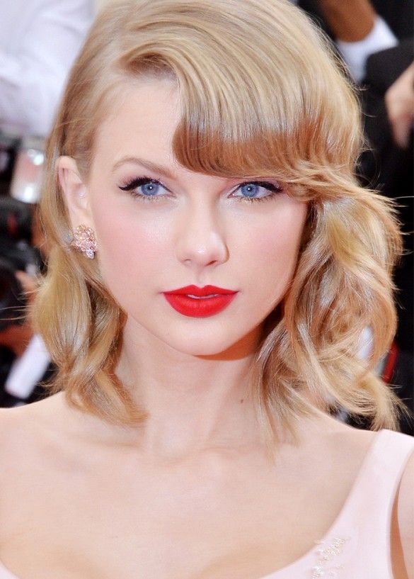 a close up of a person with red lipstick and blonde hair wearing a pink dress