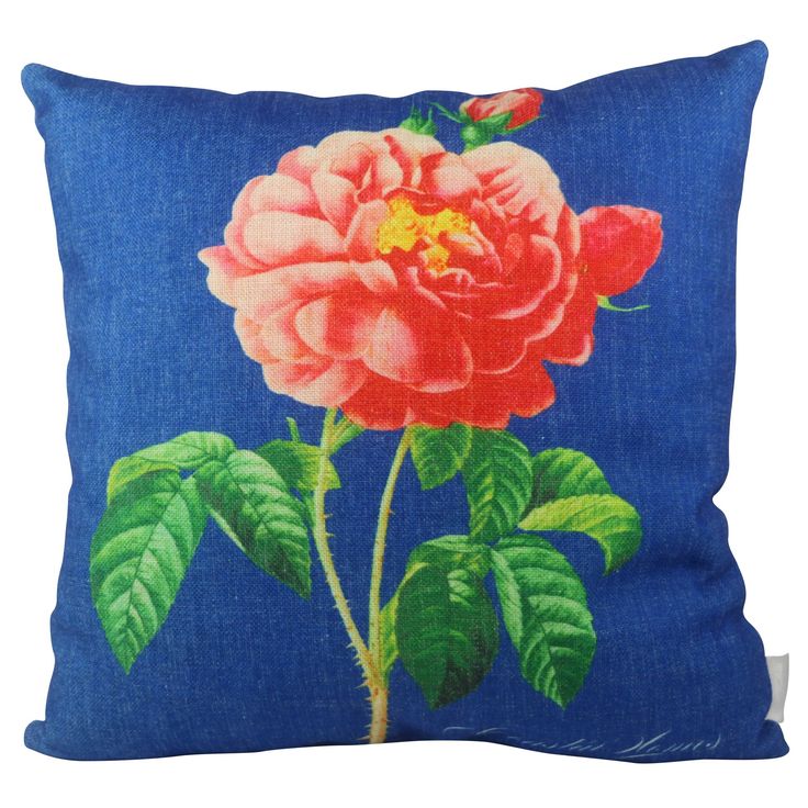 a blue pillow with a pink rose on it's side and green leaves in the middle