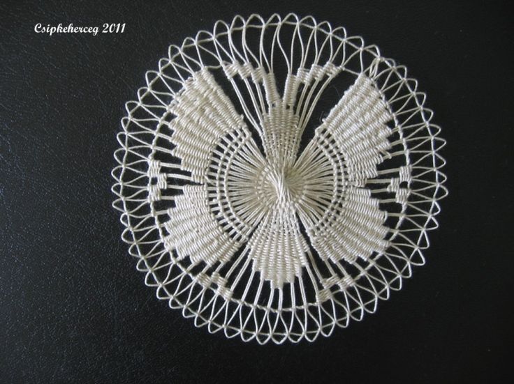 a white doily on a black surface