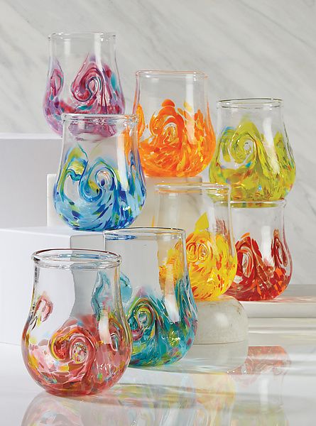 several colorful glass vases sitting on top of a white counter next to each other