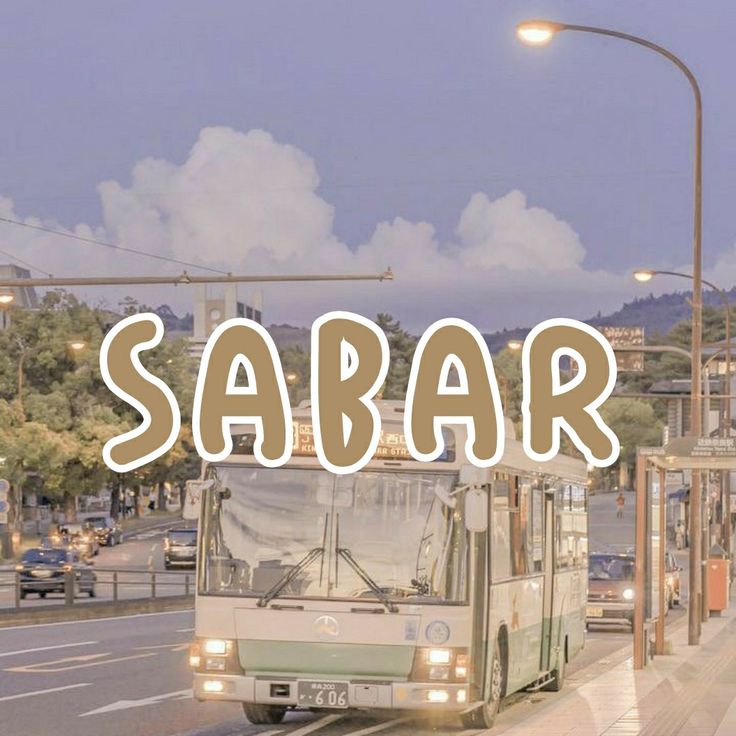 a bus driving down a street next to a tall building with the word sabar written on it