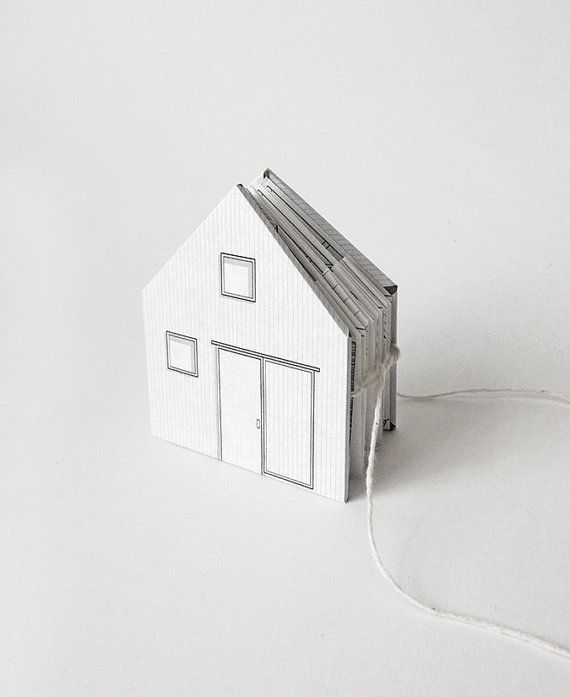 a paper house sitting on top of a white table