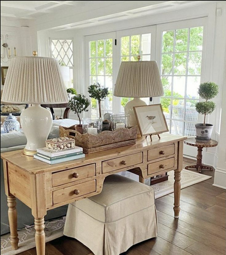 a living room filled with lots of furniture and two lamps on top of a table